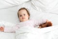 Authentic portrait cute caucasian little infant chubby baby girl or boy in pink sleepy upon waking with teddy bear Royalty Free Stock Photo