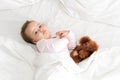 Authentic portrait cute caucasian little infant chubby baby girl or boy in pink sleepy upon waking with teddy bear Royalty Free Stock Photo