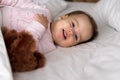 Authentic portrait cute caucasian little infant chubby baby girl or boy in pink sleepy upon waking with teddy bear