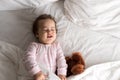 Authentic portrait cute caucasian little infant chubby baby girl or boy in pink sleepy upon waking with teddy bear Royalty Free Stock Photo