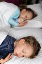 Authentic portrait cute caucasian little preschool siblings baby boy and girl in blue sleep with teddy bear on white bed