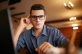 Authentic portrait of young confident businessman looking at camera with laptop in office. Hipster man in glasses and Royalty Free Stock Photo