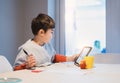 Authentic Portrait of preschool kid using tablet for his homework, New normal life child boy use touch pad for home learning, E- Royalty Free Stock Photo