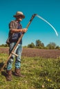 Authentic rural farmer with scythe. Agriculture worker. Sharp blade. Vegetable garden. Farm implements. Rustic background. Work