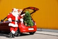 Authentic Santa Claus near red car with gift boxes Royalty Free Stock Photo