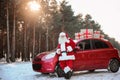 Authentic Santa Claus near red car with gift boxes Royalty Free Stock Photo