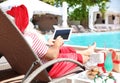 Authentic Santa Claus using tablet near pool