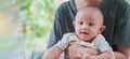 Authentic shot of Cute Asian newborn baby boy smile happy face while sitting with mother. Mom using hand take care, hug with love. Royalty Free Stock Photo