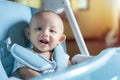 Authentic shot of Cute Asian toddler baby boy siiting on high chair, playing, looking at camera with happy smile face. Royalty Free Stock Photo