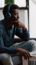 Authentic smiling african american man using laptop with headphones on, working from home Royalty Free Stock Photo