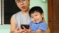 Authentic son and father looking on smartphone outdoor Royalty Free Stock Photo