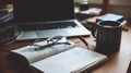 Authentic study desk with open notebook, handwritten notes, classic glasses, laptop, and coffee. Royalty Free Stock Photo
