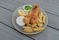 Authentic traditional british cuisine Fish and Chips served with French fries, Green peas, cut Lemon and Tartar sauce Royalty Free Stock Photo