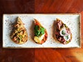 Authentic traditional spanish tapas set on wooden table for lunch, top view. Selection of bruschetta on crusty bread. Royalty Free Stock Photo