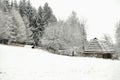 Authentic ukrainian village with wooden huts and fences in winter.