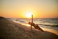 Authentic woman in swimsuit doing yoga vasisthasana on the beach in the morning. Real unretouched shape girl silhouette Royalty Free Stock Photo