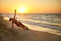 Authentic woman in swimsuit doing yoga vasisthasana on the beach in the morning. Real unretouched shape girl silhouette Royalty Free Stock Photo