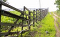 Authentic wooden fence in the village. Handmade wooden fence made of boards. Old fence, rural landscape. Well-trodden path along Royalty Free Stock Photo