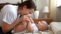 Authentic Young Caucasian Woman Holding Newborn Baby. Mom And Child On Bed. Close-up Portrait of Smiling Family With Royalty Free Stock Photo