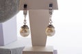 author beautiful earrings with pearls demonstrated around white backround. fashion and jewelry concept