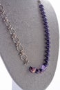 Author trend necklace with chain and purple reals demonstrated on maneken. fashion and jewelry concept