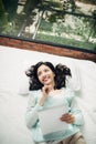 Author, Typewriter, Journalist. Intelligent woman lying on bed a Royalty Free Stock Photo