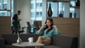 Authoritative manager talking phone at sofa. Smiling businesswoman at office
