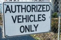 Authorized vehicles only sign on steel fence