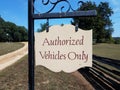 Authorized vehicles only sign with wood fence and grass