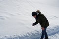 Autisitic teenager boy picking snow in order to feel it and observe it