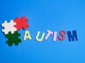 Autism awareness concept with jigsaw puzzles on blue background.