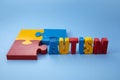 Autism awareness concept with puzzle and word autism on blue background. Royalty Free Stock Photo