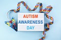 Autism awareness day or month. Paper plane in origami style with autism awareness puzzle ribbon on blue background.