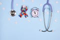 Autism concept with puzzle awareness ribbon, stethoscope and alarm clock on a blue background. Autism Awareness Day Royalty Free Stock Photo