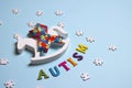 Autism concept with toy rocking horse and and puzzle awareness ribbon on a blue background Royalty Free Stock Photo