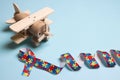 Autism concept with wooden toy plane and puzzle awareness ribbon on a blue background Royalty Free Stock Photo