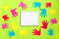AUTISM. Cut out of colored paper children palms around white frame on light green background. World Autism Awareness Day