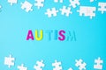 AUTISM text with white puzzle jigsaw pieces on blue background. Concepts of health, Autistic Spectrum disorder and world Autism Royalty Free Stock Photo