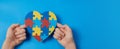 Autistic boy hands holding jigsaw puzzle heart shape. Autism spectrum disorder family support concept. World Autism Royalty Free Stock Photo