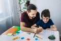 Autistic boy during therapy at home with his father with learning and having fun together. Autism awareness concept