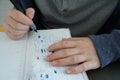 Autistic male teenager writes capital letters Royalty Free Stock Photo