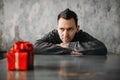 Autist man sitting against gift in wrapping paper Royalty Free Stock Photo