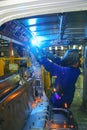 Auto bodies is welded by an arc welding operator with his protective gear on.