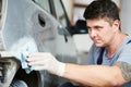 Auto repairman plastering autobody bonnet