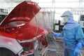 An auto body is spray painted by and human operator in the paint shop. Royalty Free Stock Photo