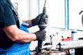 Auto car mechanic adjusting a car shock absorber