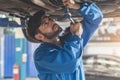 Auto check up and car service shop. Mechanic writing job checklist to clipboard to estimate repair quotation to client at Royalty Free Stock Photo