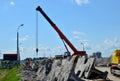 Auto crane loads an old concrete slab into a dump truck at a construction site. Royalty Free Stock Photo