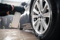 Auto detailing worker applies chemistry to wheels. Professional car wheel wash.