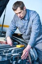 Auto electrician mechanic at work with tester